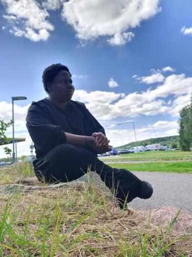 a man sitting on the grass on the side of a road at Apartment in Espoo