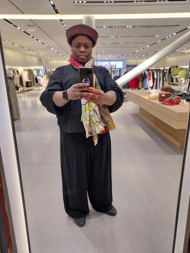 a woman standing in a store taking a picture in a mirror at Apartment in Espoo
