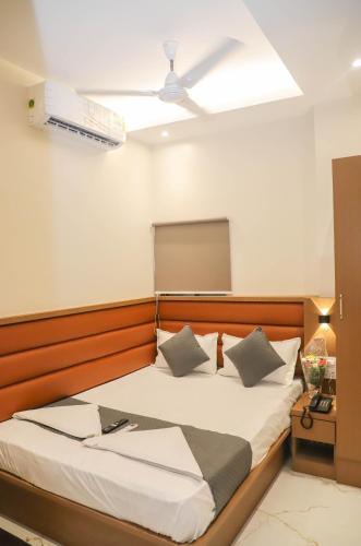 ein Schlafzimmer mit einem großen Bett mit avertisementatronatronstrationstrationstrationstrationstration in der Unterkunft Hotel Pramila in Mumbai