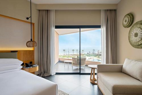 a hotel room with a bed and a couch at Taghazout Bay Marriott Resort in Taghazout