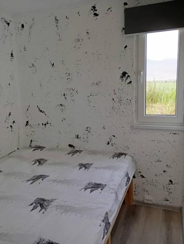 a bedroom with a bed with a wall covered in debris at ИНХаус Долинка in Cholpon-Ata