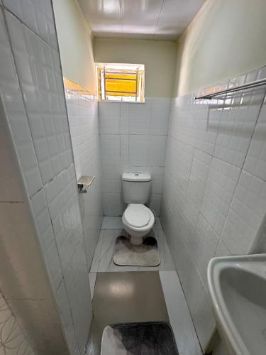 a small bathroom with a toilet and a sink at ELISAM Cabin 2 in Kitwe