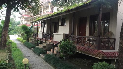 a house with a pathway next to a building at Chitwan Forest Resort , Chitwan National Park in Sauraha