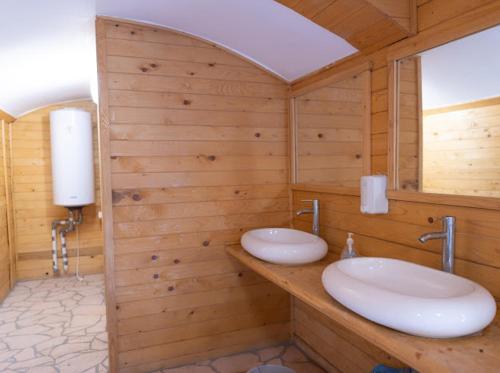 a bathroom with two sinks in a wooden wall at Ograda Bunicului Seaca in Gura Văii