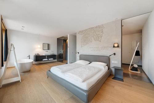 a bedroom with a bed and a bath tub and a bathroom at Wine Lodge Pratenberg in Merano