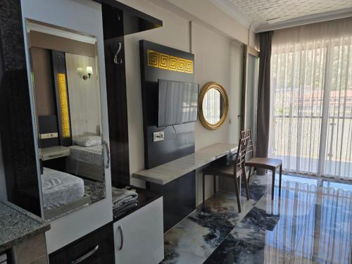 a room with a desk and a mirror and a table at Haciely Thermal Otel in Denizli