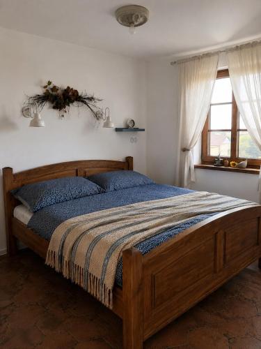 a bedroom with a wooden bed in a room with a window at Kokodáák in Troskotovice