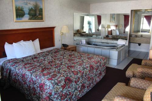 a hotel room with a large bed and a sink at Highlander Motor Inn Atlantic City in Galloway