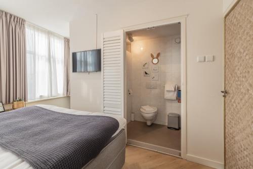 sypialnia z łóżkiem i łazienką z toaletą w obiekcie LOT Hotel w Lejdzie