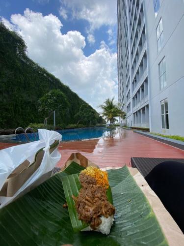a plate of food sitting on top of a banana leaf at Halo Apartemen in Kebomas