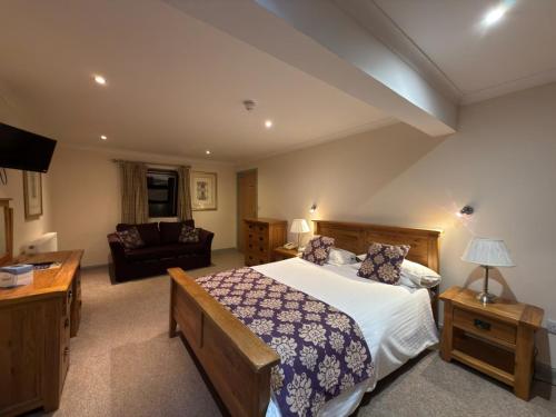 a bedroom with a large bed and a couch at Craigmonie Hotel Inverness by Compass Hospitality in Inverness