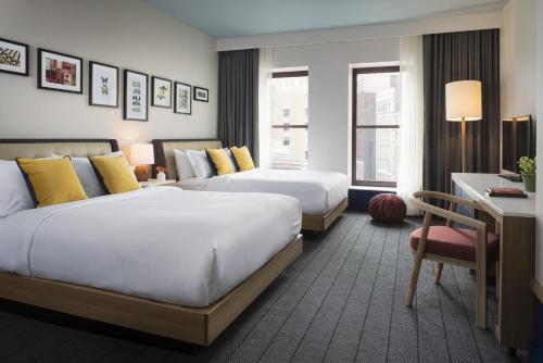 a hotel room with two beds and a desk at Kimpton Schofield Hotel by IHG in Cleveland