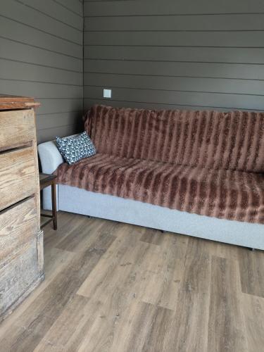 a large couch in a room with a wooden floor at Owls' house B&B in Skriaudžiai
