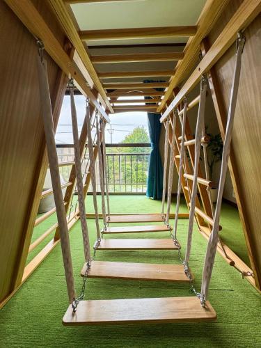 a wooden staircase in a room with green carpet at Asobico焼津 in Yaizu