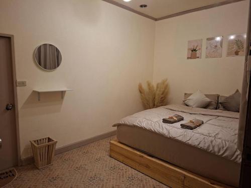 a bedroom with a bed with two shoes on it at U House Homeytel in Ban Tai