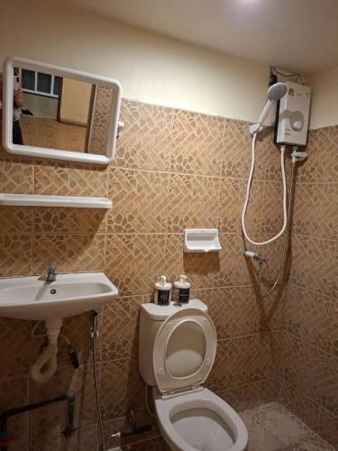a bathroom with a shower and a toilet and a sink at U House Homeytel in Ban Tai