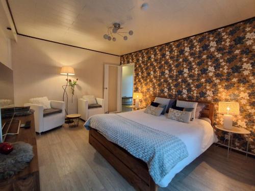 a bedroom with a large bed and a living room at Les Mésanges Bleu in Malmedy