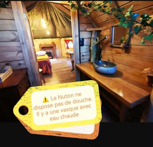 a sign on a table in a room at La cabane du Nuton Ardennais in Tournes