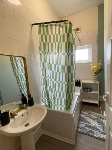 a bathroom with a sink and a shower curtain at The Blackburn 2 Bedroom House in Cherry Tree