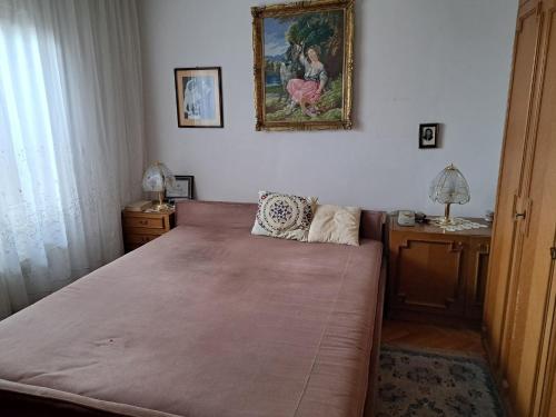 a bedroom with a bed and a picture on the wall at City centar apartman in Zaječar