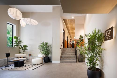 a lobby with potted plants and a staircase at Pixel Dizengoff Square - Hotel & Spa in Tel Aviv