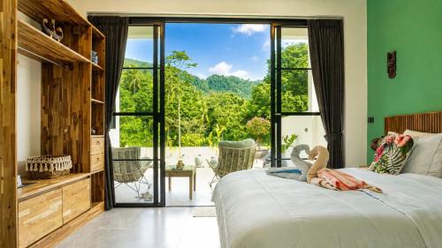 a woman laying on a bed in a bedroom with a view at Villa des Princes in Ban Thung