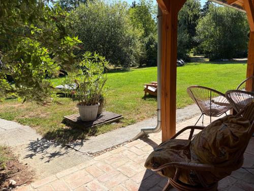 a patio with two chairs and a table and a bench at Fonfa Liget in Sénye
