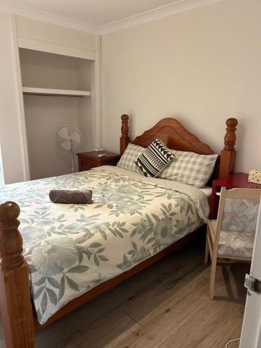 a bedroom with a bed with a wooden headboard at R1 Bright Spacious Room near Perth Airport in Perth