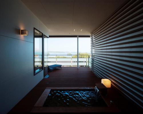 a room with a tub with a view of the ocean at Amakusa Tenku No Fune in Kami Amakusa