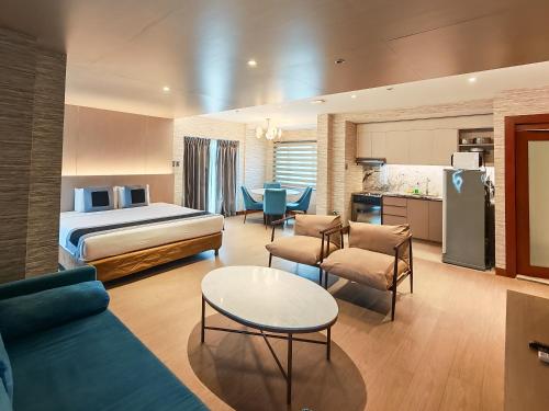 a hotel room with a bed and a living room at City Garden Suites Manila in Manila