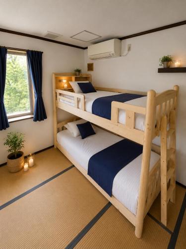 a bedroom with two bunk beds and a window at Heart Warmer in Myoko