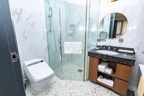 a bathroom with a shower and a toilet and a sink at Dyne Oceano Hotel in Jeju