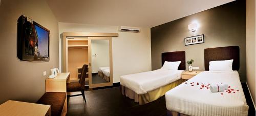 a hotel room with two beds and a flat screen tv at Sky Hotel @ Selayang in Batu Caves
