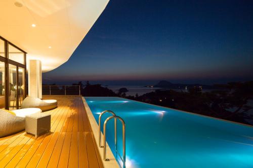 a villa with a swimming pool at night at Amakusa Tenku No Fune in Kami Amakusa
