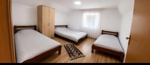 a small room with two beds and a window at Breti's GuestHouse in Vusanje