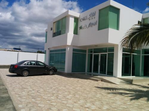 een zwarte auto geparkeerd voor een gebouw bij Manta Airport Hotel in Manta