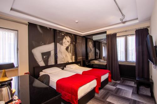 a hotel room with a bed with a red blanket at Maltepe 2000 Hotel in Ankara