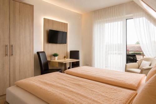 a hotel room with two beds and a television at Gästehaus Stillecke in Erwitte
