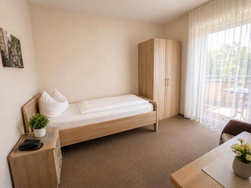 a small room with a bed and a window at Gästehaus Stillecke in Erwitte