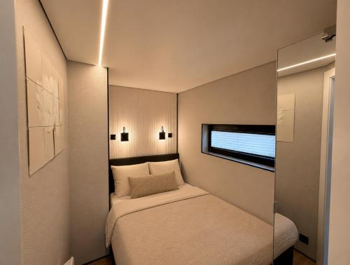 a small bedroom with a bed and a window at Luxury Houseboat Wolphaartsdijk VP109 in Wolphaartsdijk