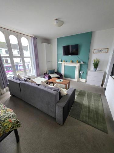 a living room with a couch and a tv at Lavish Lounge in Swansea