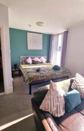 a room with two beds and a couch in it at Lavish Lounge in Swansea