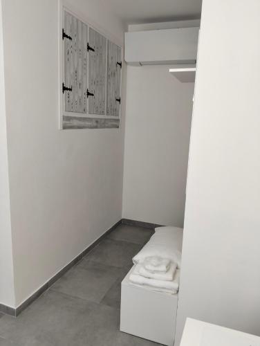 a white room with a bed and a pile of towels at La Casa di Mami in Velletri