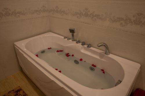 a white bath tub with red roses in it at Trieu Khang Hotel gần sân bay Cam Ranh near Cam Ranh Airport in Cam Ranh