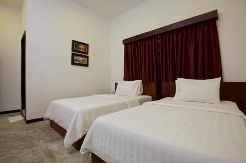 two beds in a hotel room with white sheets at Chhouy Vathna Angkor Boutique in Siem Reap