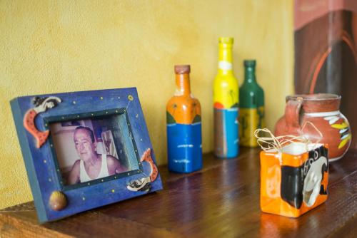 a picture of a man in a box on a table with bottles at Cabañas del Capitan in Rincon de Guayabitos