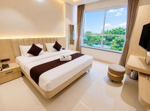 ein Schlafzimmer mit einem großen Bett und einem großen Fenster in der Unterkunft Hotel Mewada in Ujjain