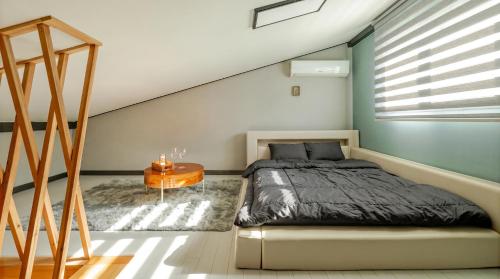 a bedroom with a bed and a table at Hongcheon Pension 150 in Hongcheon