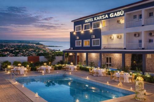 a hotel with a swimming pool in front of a building at Hotel Gabu Karsa in Gabú