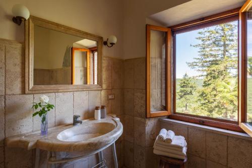 a bathroom with a sink and a large window at Il Casone di Rigomagno in Rigomagno